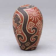 A polychrome seed pot decorated with a lightly carved and painted fish, sun, flower and geometric design, click or tap to see a larger version