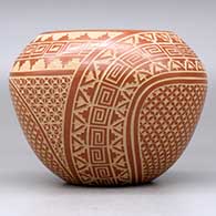 A red jar decorated with a sgraffito snowflake, scroll, kiva step and geometric design, click or tap to see a larger version