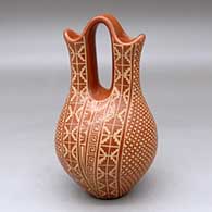 A red wedding vase decorated with a sgraffito four-panel snowflake and geometric design
 by Wilma Baca Tosa of Jemez