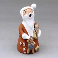 A standing Santa Claus storyteller figure with two children and gifts
 by Diane Lucero of Jemez