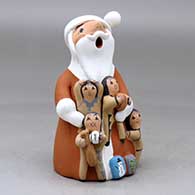 A standing Santa Claus storyteller figure with four children and gifts, click or tap to see a larger version