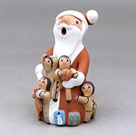 A standing Santa Claus storyteller figure with four children and gifts
 by Diane Lucero of Jemez