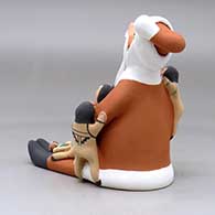 A sitting Santa Claus storyteller figure with five children and gifts, click or tap to see a larger version