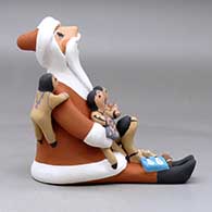 A sitting Santa Claus storyteller figure with five children and gifts, click or tap to see a larger version