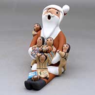 A sitting Santa Claus storyteller figure with five children and gifts
 by Diane Lucero of Jemez