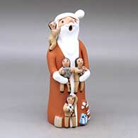 A standing Santa Claus storyteller figure with four children and gifts
 by Diane Lucero of Jemez