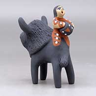 A polychrome figure with a little girl and her drum on the back of a bison, click or tap to see a larger version