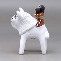 A polychrome figure with a little girl holding her younger sister and her drum on the back of a sacred white bison, click or tap to see a larger version