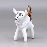 A polychrome figure with a little girl holding her younger sister and her drum on the back of a sacred white bison, click or tap to see a larger version