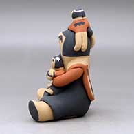 A sitting grandmother storyteller figure with four children on her, click or tap to see a larger version
