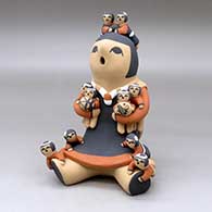 A sitting grandmother storyteller figure with 10 children on her
 by Vernida Toya of Jemez