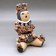 A sitting grandmother storyteller figure with 20 children on her
 by Vernida Toya of Jemez