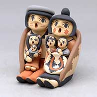 A grandmother and grandfather storyteller pair wearing a manta with four children and a welcome basket
 by Chrislyn Fragua of Jemez