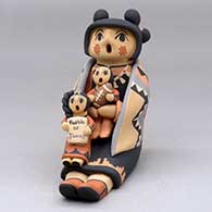 A sitting grandmother storyteller wearing a manta and holding two children with gifts
 by Chrislyn Fragua of Jemez
