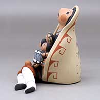 A sitting grandmother storyteller wearing a manta with four children, a drum and a welcome basket, click or tap to see a larger version