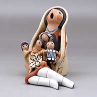 A sitting grandmother storyteller wearing a manta with four children, a drum and a welcome basket, click or tap to see a larger version