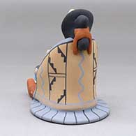 A sitting grandmother storyteller wearing a manta and skirt with four children, a puppy and a drum, click or tap to see a larger version