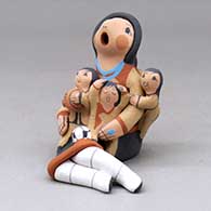A sitting grandmother storyteller figure with three children, a football and a soccer ball
 by Diane Lucero of Jemez