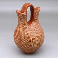 A red wedding vase decorated with a sgraffito scroll, kiva step, snowflake and geometric design
 by Wilma Baca Tosa of Jemez