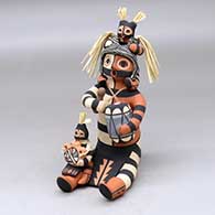 A sitting koshare storyteller figure with a drum, two children and a canteen
 by Linda Lucero Fragua of Jemez