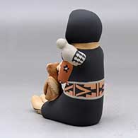 A sitting Singing Mother holding a bird, puppy, kitten and canteen, click or tap to see a larger version