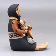 A sitting Singing Mother holding a bird, puppy, kitten and canteen, click or tap to see a larger version