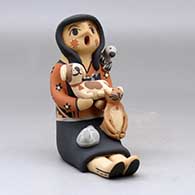 A sitting Singing Mother holding a bird, puppy, kitten and canteen, click or tap to see a larger version