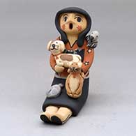 A sitting Singing Mother holding a bird, puppy, kitten and canteen
 by Chrislyn Fragua of Jemez
