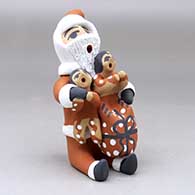 A sitting Santa Claus storyteller figure with two children and gifts, click or tap to see a larger version