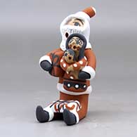 A sitting Santa Claus storyteller figure with two children and gifts, click or tap to see a larger version