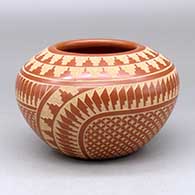 A red jar decorated with a sgraffito kiva step, feather, snowflake and geometric design
 by Wilma Baca Tosa of Jemez