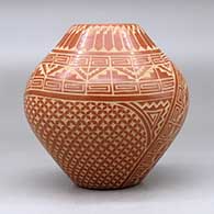 A red jar decorated with a sgraffito spiral, kiva step, feather and geometric design, click or tap to see a larger version