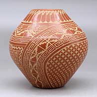 A red jar decorated with a sgraffito spiral, kiva step, feather and geometric design, click or tap to see a larger version
