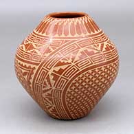 A red jar decorated with a sgraffito spiral, kiva step, feather and geometric design
 by Wilma Baca Tosa of Jemez
