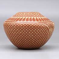 A red jar decorated with a sgraffito snowflake, feather, kiva step and geometric design, click or tap to see a larger version