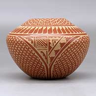 A red jar decorated with a sgraffito snowflake, feather, kiva step and geometric design, click or tap to see a larger version