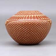 A red jar decorated with a sgraffito snowflake, feather, kiva step and geometric design, click or tap to see a larger version
