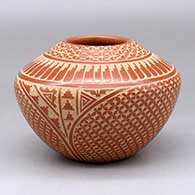 A red jar decorated with a sgraffito snowflake, feather, kiva step and geometric design
 by Wilma Baca Tosa of Jemez
