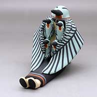 A sitting hummingbird storyteller with four chicks
 by Loren Wallowing Bull of Jemez