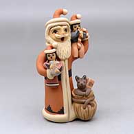 A standing Santa Claus storyteller figure with two children holding gifts and a bag of gifts at his feet, plus a puppy
 by Linda Lucero Fragua of Jemez