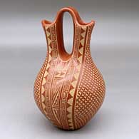 A red wedding vase decorated with a sgraffito snowflake, scroll, kiva step and geometric design
 by Wilma Baca Tosa of Jemez