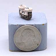 A miniature black-on-white two-opening jar decorated with a geometric design, click or tap to see a larger version