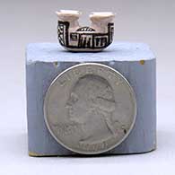 A miniature black-on-white two-opening jar decorated with a geometric design, click or tap to see a larger version