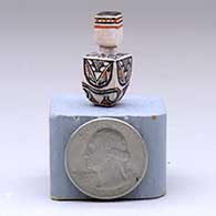 A miniature lidded polychrome square jar decorated with a four-panel geometric design, click or tap to see a larger version