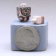 A miniature lidded polychrome square jar decorated with a four-panel geometric design, click or tap to see a larger version