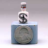 A miniature lidded three-sided jar decorated with a Mimbres figure and geometric design, click or tap to see a larger version
