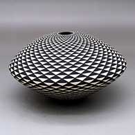 A black-on-white seed pot decorated with a spiral mesa geometric design
 by Robert Kasero Sr of Laguna