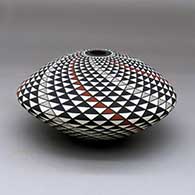 A polychrome seed pot decorated with a spiral mesa geometric design, click or tap to see a larger version