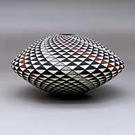 A polychrome seed pot decorated with a spiral mesa geometric design, click or tap to see a larger version