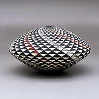 A polychrome seed pot decorated with a spiral mesa geometric design, click or tap to see a larger version